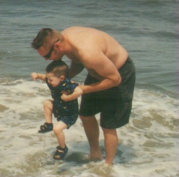 Rocky helping Tyler with his first dip in the ocean